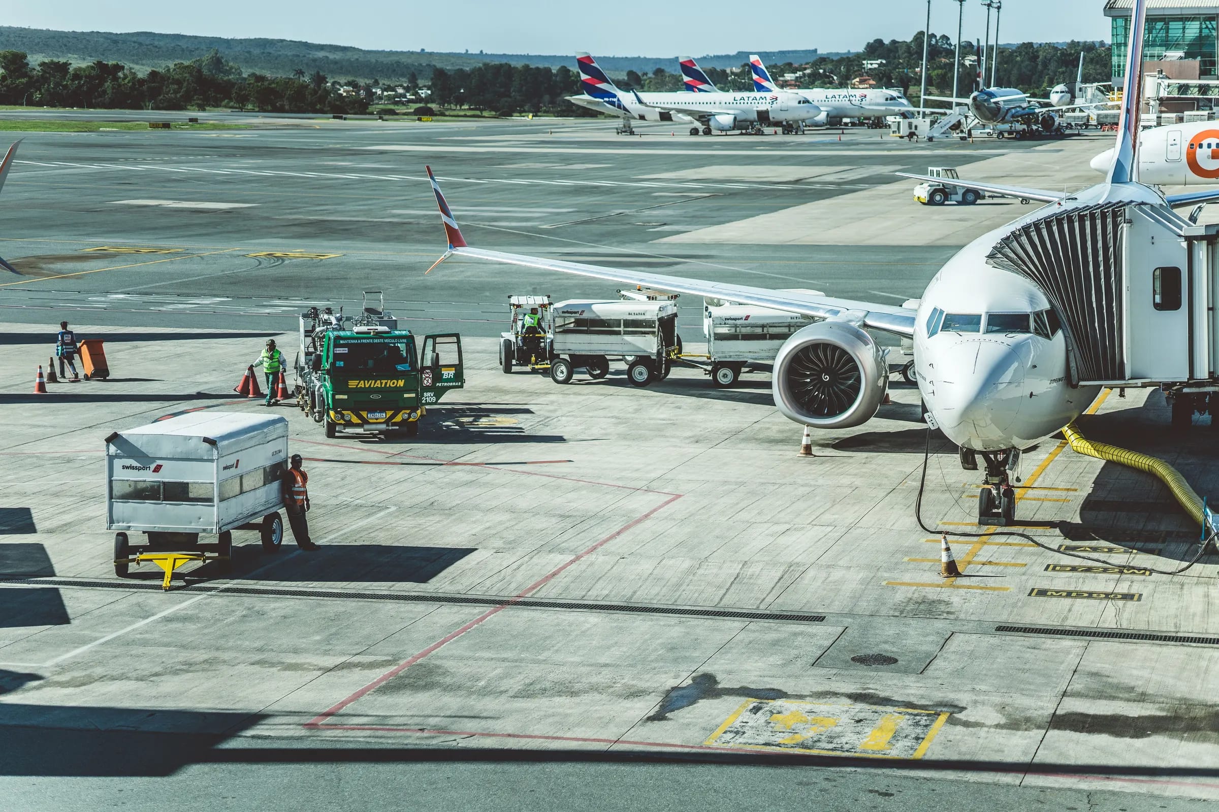 Aircraft at the gate with ground support vehicles on the apron